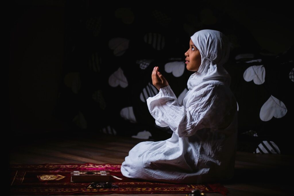 Beautiful Islamic Poems: A Reflection on Divine Love A young Muslim woman in white attire, deeply engaged in prayer, surrounded by beautiful Islamic poems.