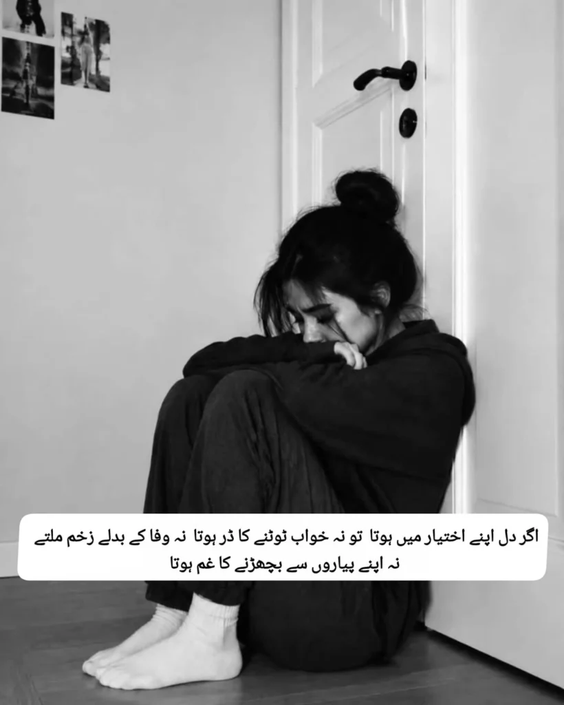 Heartbroken girl sitting on the floor beside a door reading dil ikhtiyar mein hota poetry
