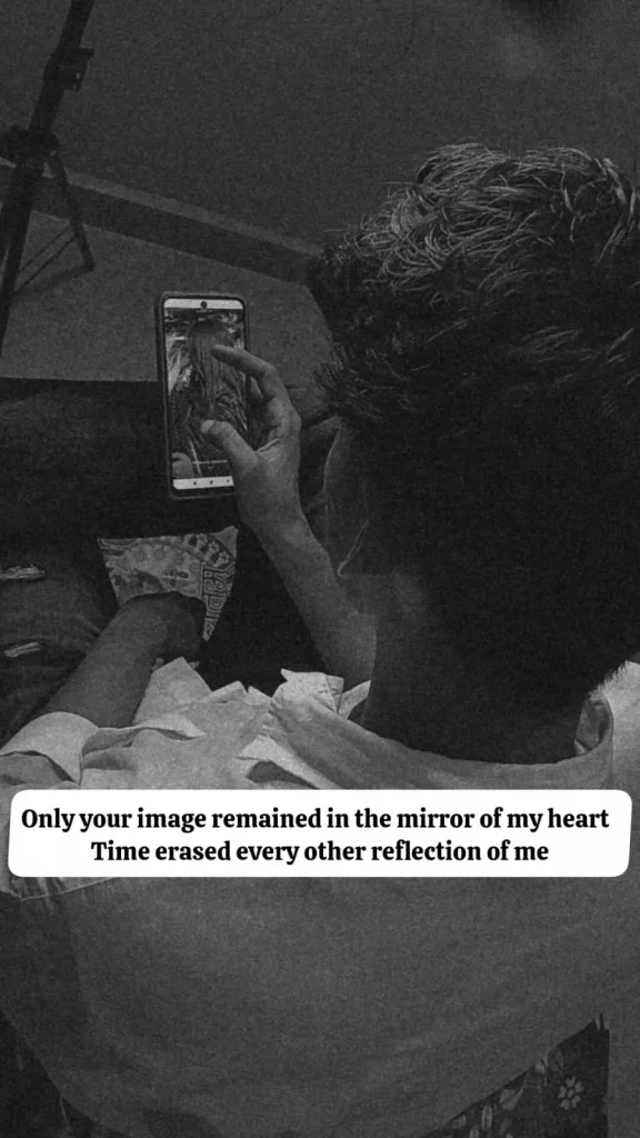 khud ko khona ishq mein — man looking at an old photo on his phone alone in the dark